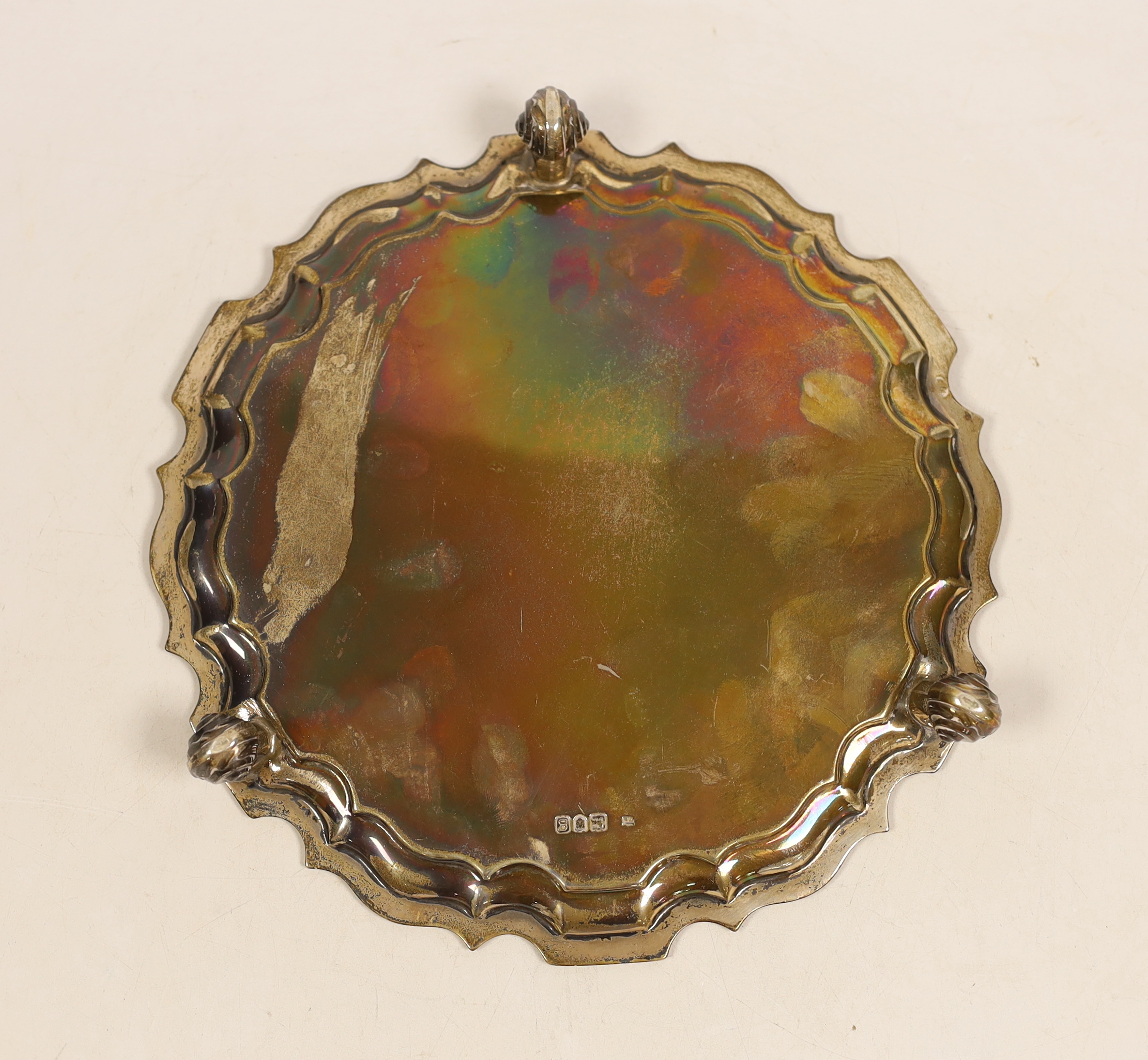 An Edwardian circular silver salver with piecrust border on three scroll feet, engraved Pilkington family crest, 